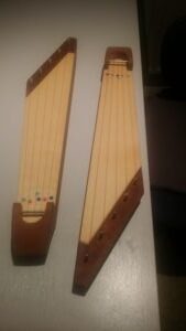 Two wooden zither halves are displayed on a table